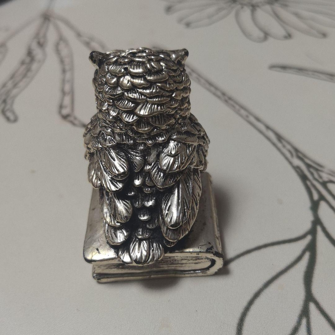 フクロウの金属製置物 本の上に座る