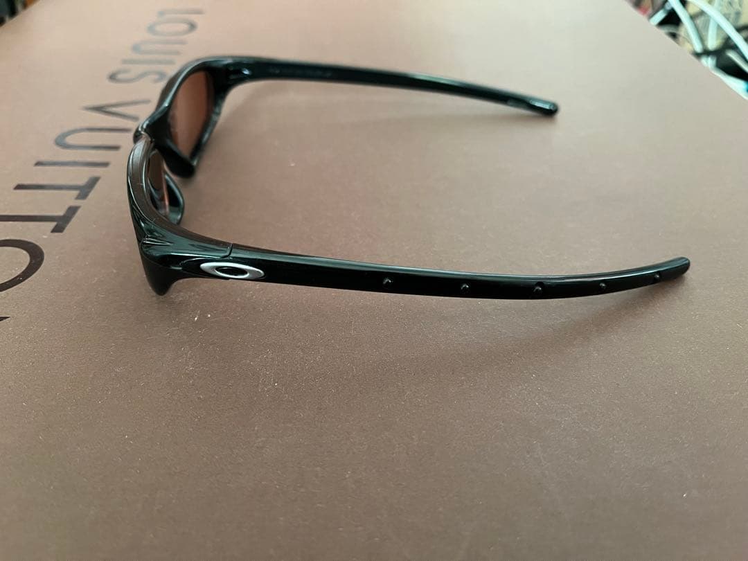 Oakley スポーツサングラス 黒 オレンジの度付きレンズ