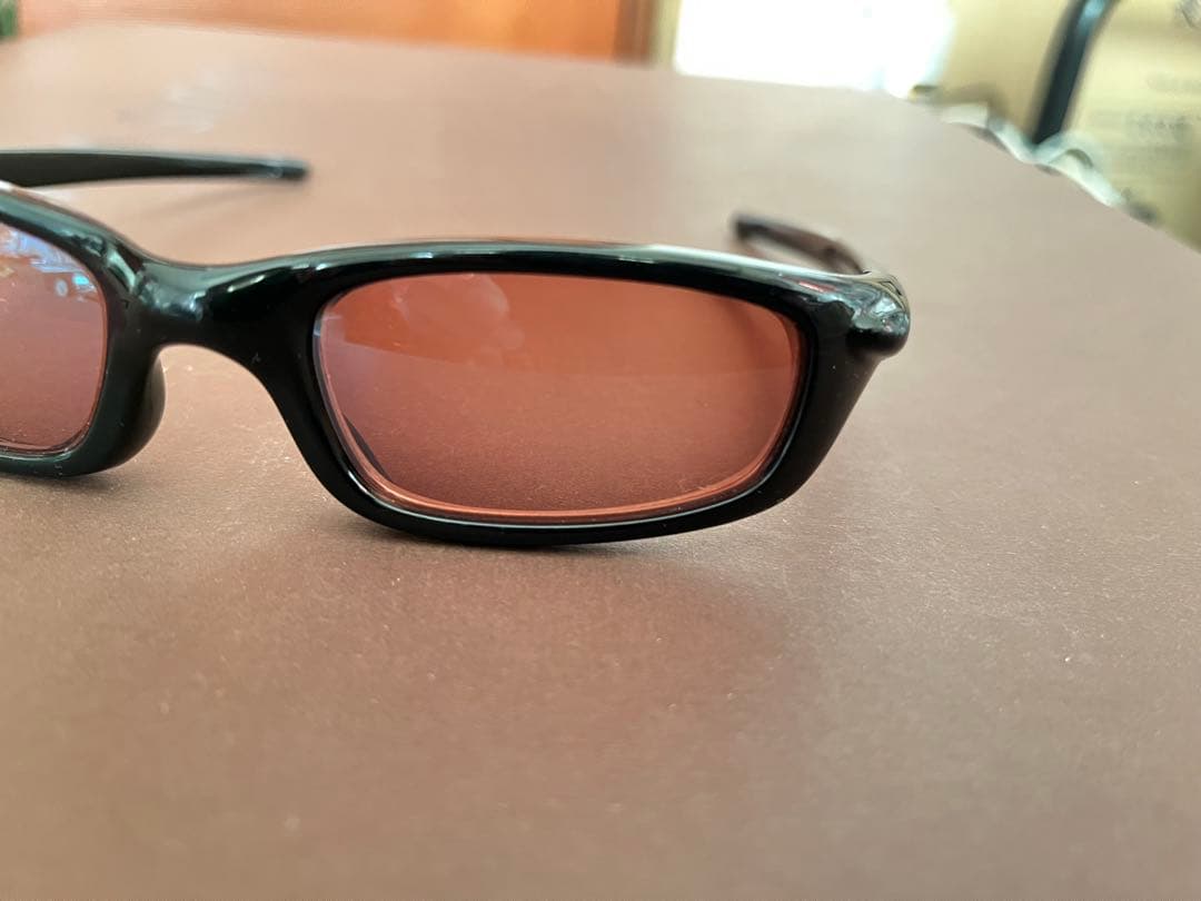 Oakley スポーツサングラス 黒 オレンジの度付きレンズ