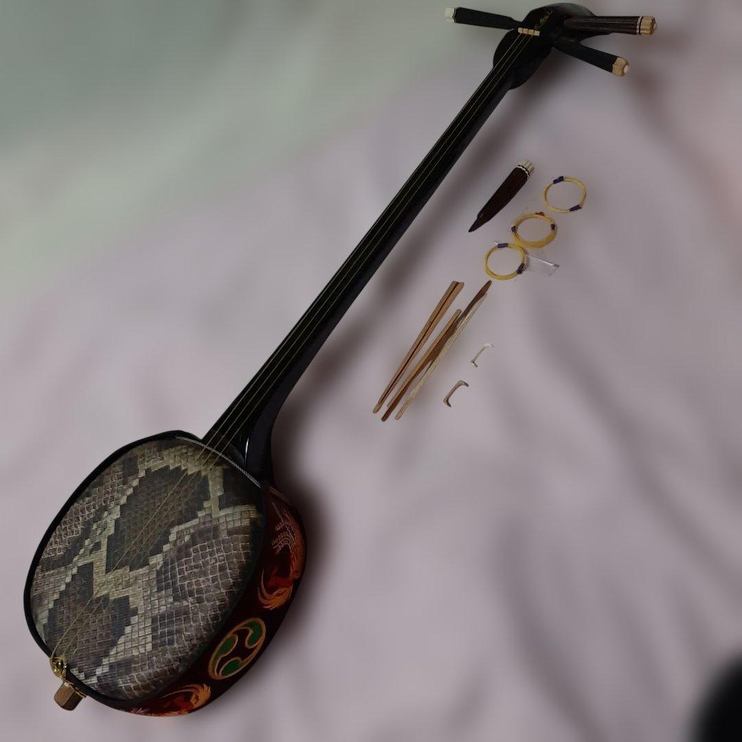 特上沖縄三線◆蛇柄デザイン人工皮革製◆手掛け金色刺繍左三つ巴◆ハードケース付き