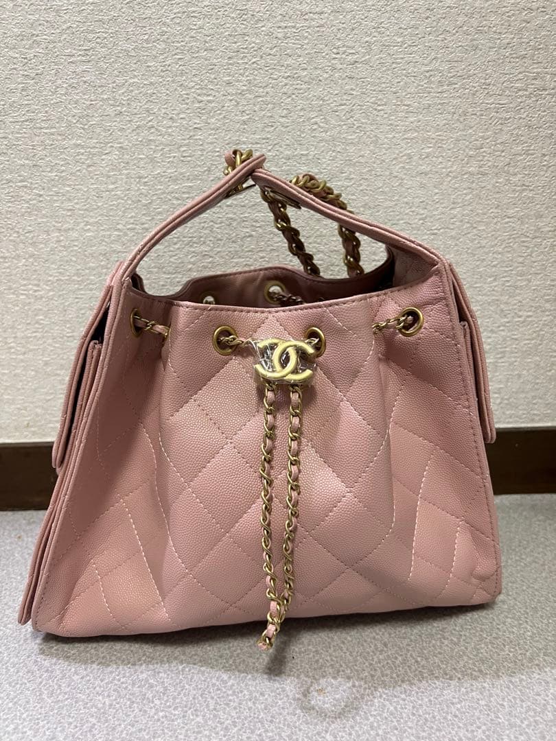 ゴールドチェーンが付いたピンクのキルティングレザーショルダーバッグ。
