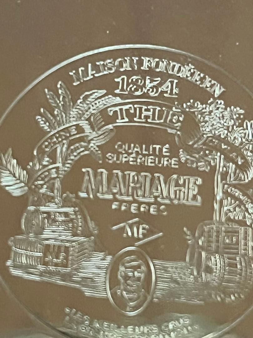 紅茶ブティック　メゾン　マリアージュの銀色プレートに刻印缶入り茶葉。