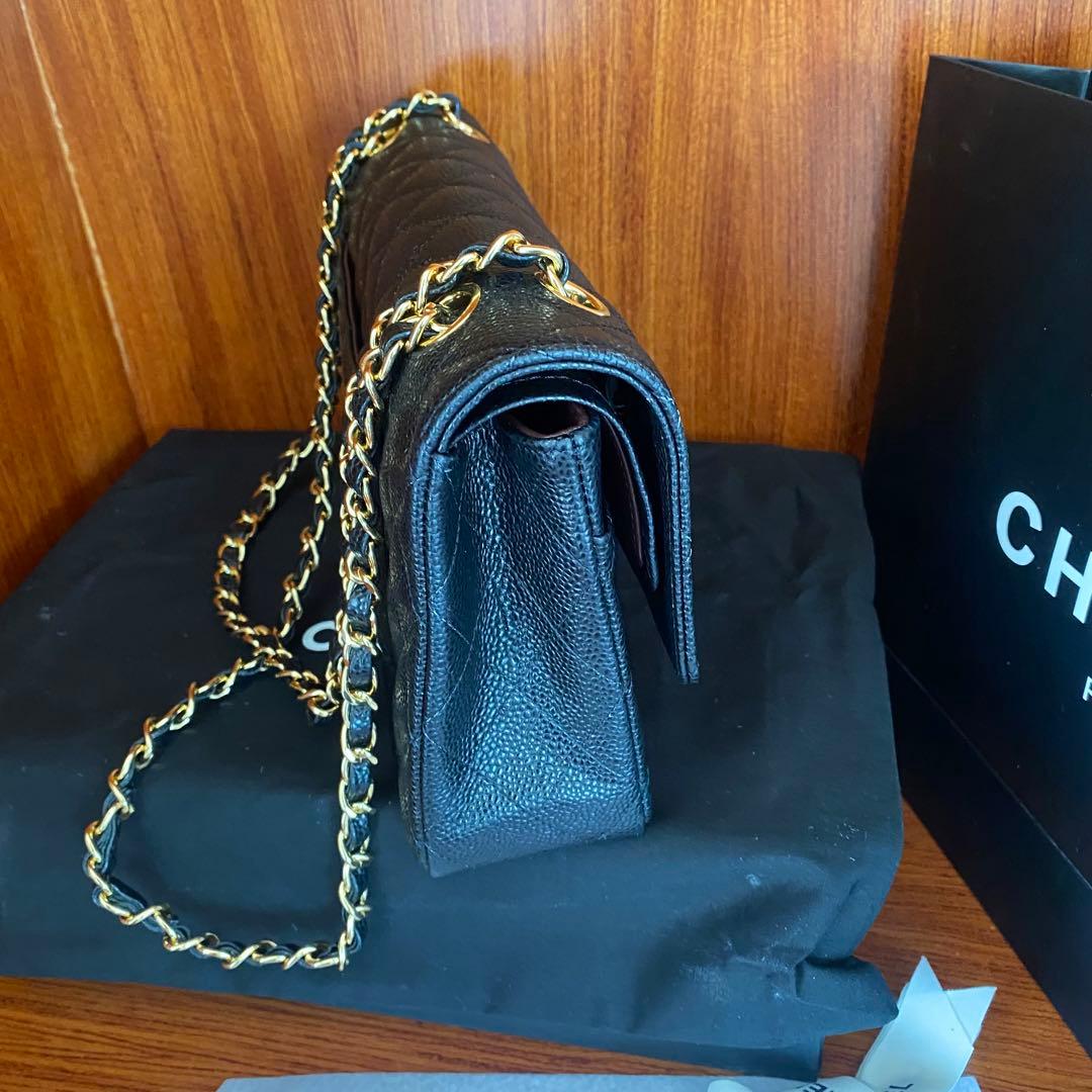 ブラックレザーのキルティングデザイン、ゴールドチェーン付きのショルダーバッグ。