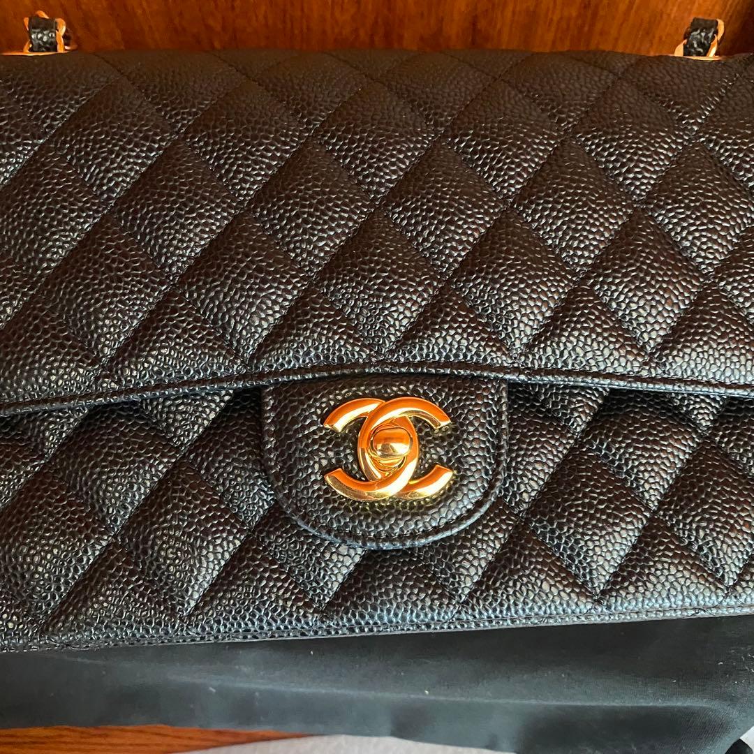 ブラックレザーのキルティングデザイン、ゴールドチェーン付きのショルダーバッグ。