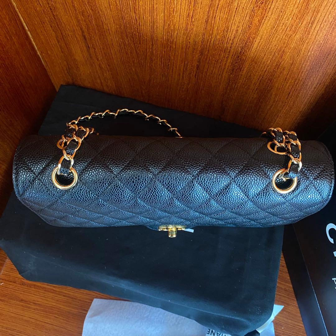 ブラックレザーのキルティングデザイン、ゴールドチェーン付きのショルダーバッグ。