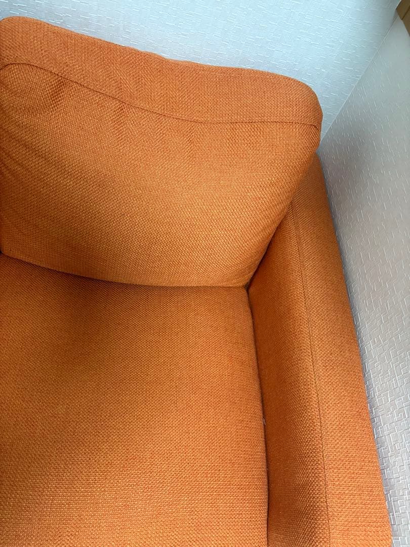 オレンジ色の3人掛けソファ