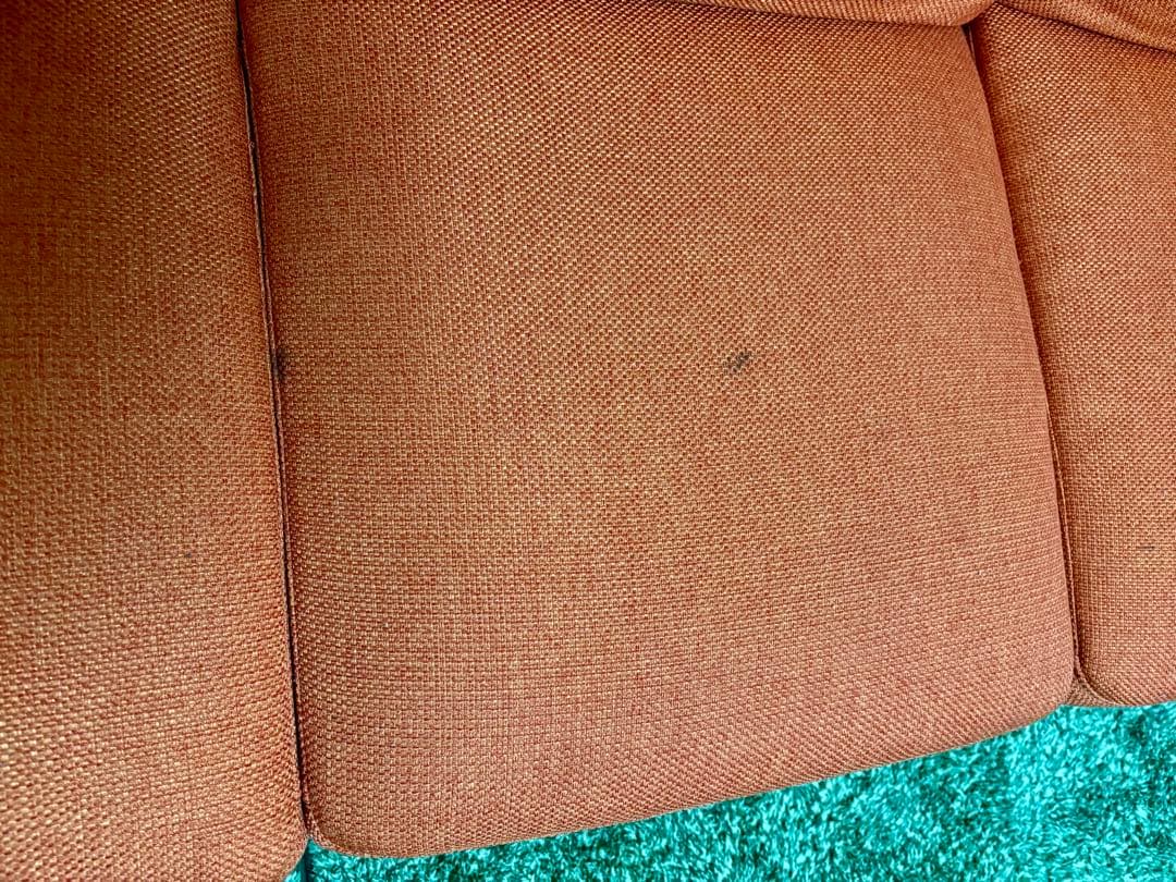 オレンジ色の3人掛けソファ