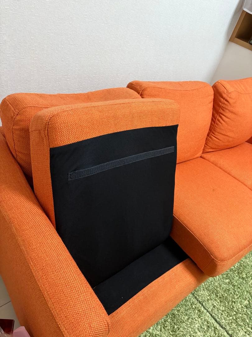 オレンジ色の3人掛けソファ