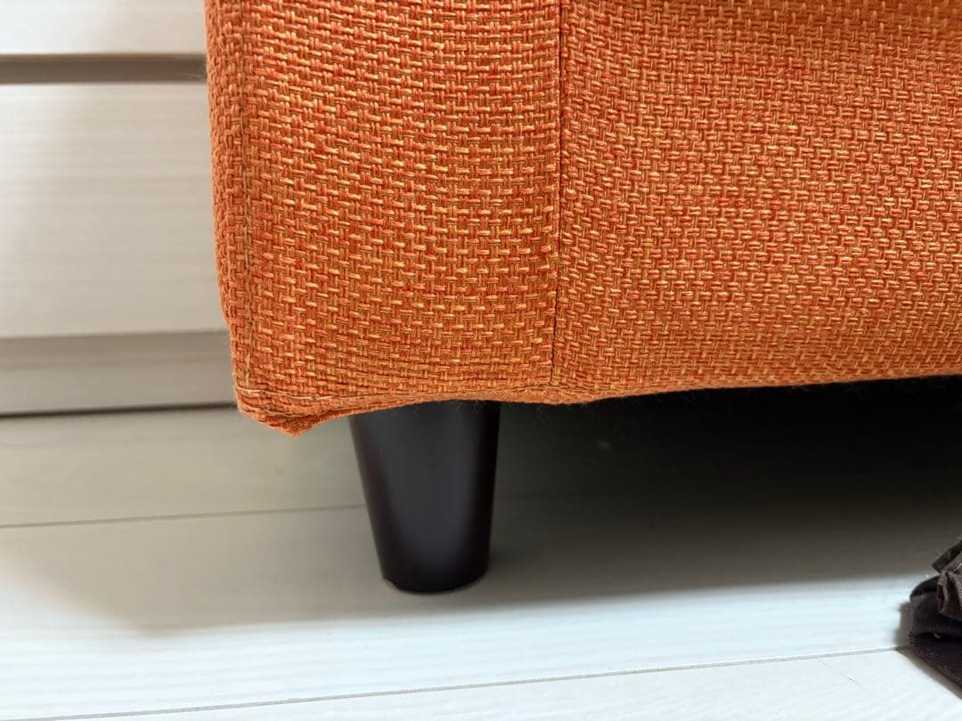 オレンジ色の3人掛けソファ